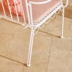 Chaise d'extérieur en fer festonnée blanche avec coussin rose
