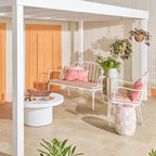 Chaise d'extérieur en fer festonnée blanche avec coussin rose